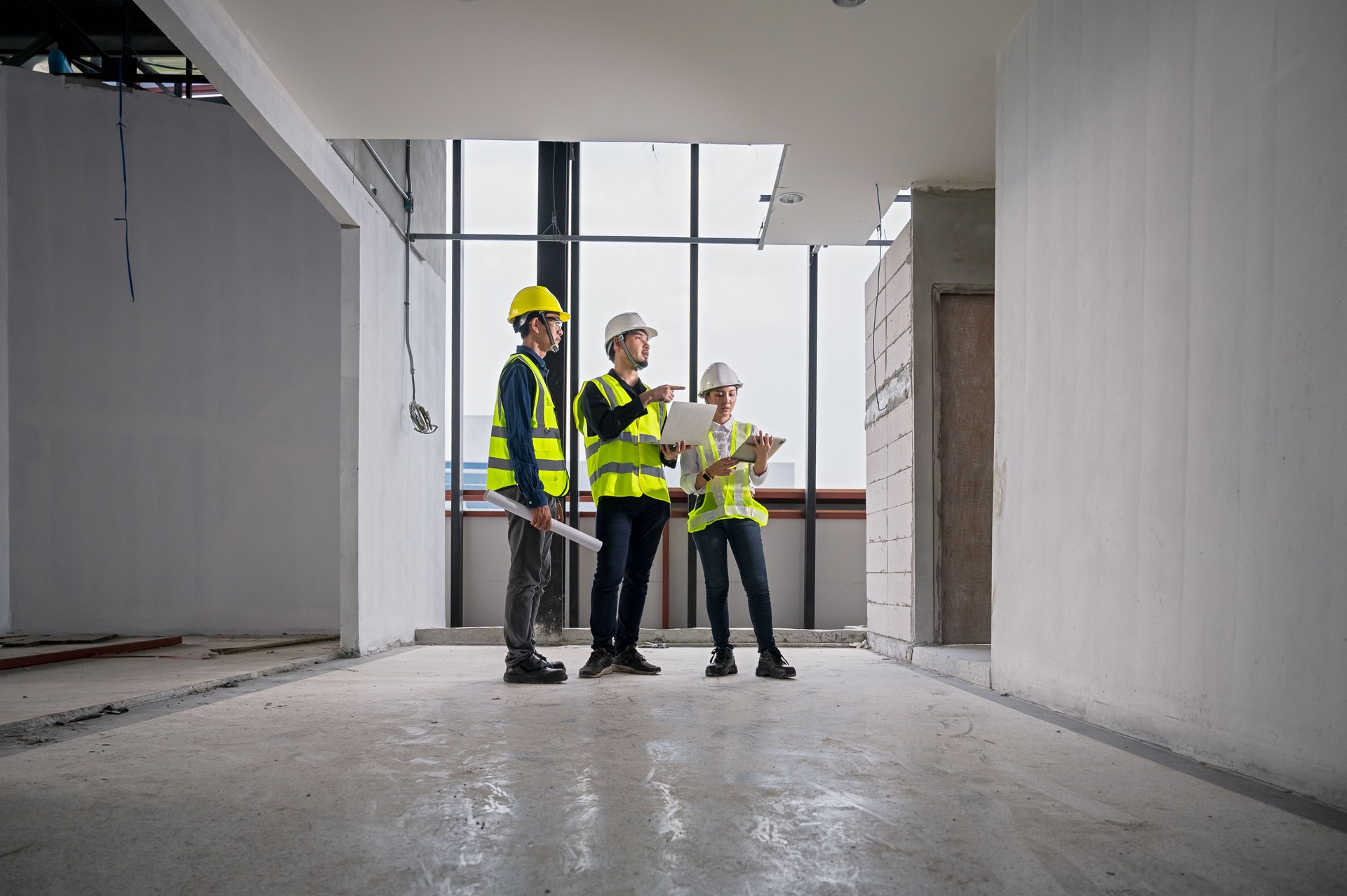 Engineer, architect and construction supervisor Use tablet to record information while inspecting construction work. Construction supervisor, architect or engineer inspect construction inside building